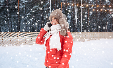 Image showing woman calling on smartphone over ice skating rink