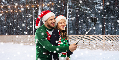 Image showing happy couple in christmas sweaters taking selfie