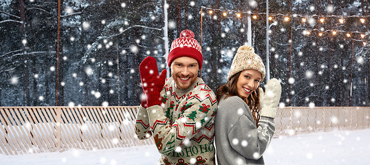 Image showing couple in ugly sweaters on christmas ice rink