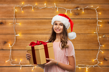 Image showing teenage girl in santa hat with christmas gift