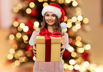 Image showing teenage girl in santa hat with christmas gift