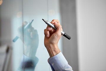 Image showing hand with marker and sticker on glass at office