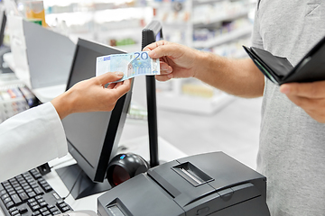 Image showing pharmacist taking money from customer at pharmacy