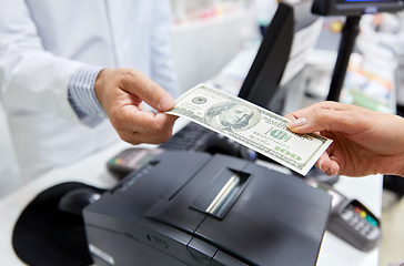 Image showing pharmacist taking money from customer at pharmacy