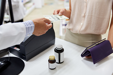 Image showing pharmacist taking money from customer at pharmacy