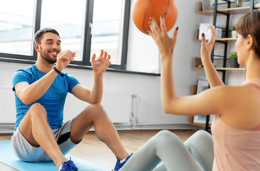 Image showing happy couple exercising with ball at home