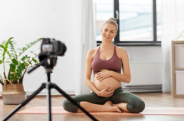 Image showing pregnant woman or yoga blogger with camera at home