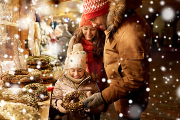 Image showing happy family buying wreath at christmas market