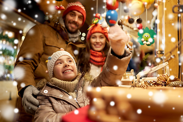 Image showing happy family buying souvenirs at christmas market