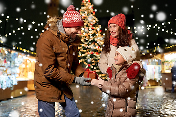 Image showing happy family with gift at christmas market in city