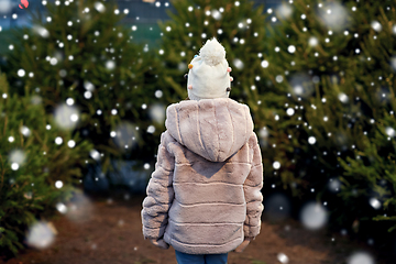 Image showing little girl choosing christmas tree at market