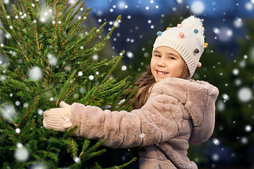 Image showing little girl choosing christmas tree at market