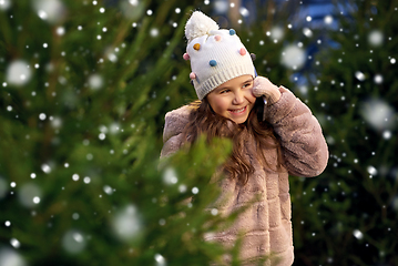 Image showing girl calling on smartphone over christmas trees
