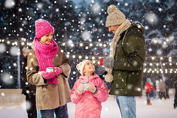 Image showing happy family drinking hot tea on skating rink