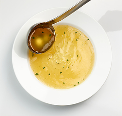 Image showing chicken broth pouring into soup plate