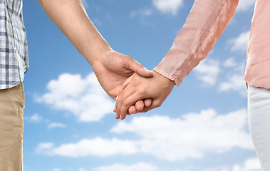 Image showing close up of happy couple holding hands at home