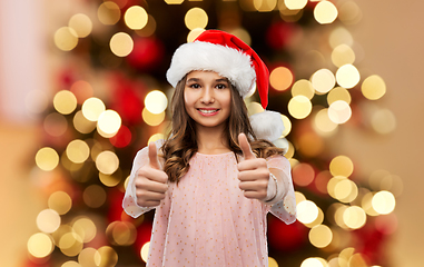 Image showing happy teenage girl showing thumbs up on christmas