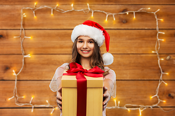 Image showing teenage girl in santa hat with christmas gift