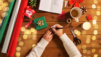 Image showing hands attaching name tag to christmas gift