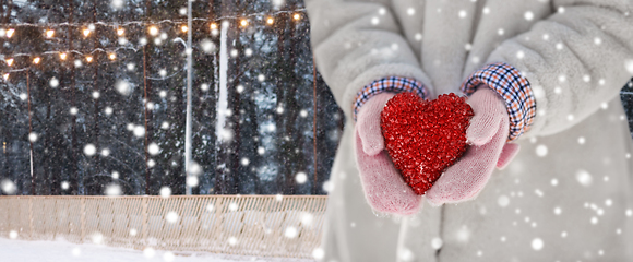 Image showing close up of little girl holding heart in winter