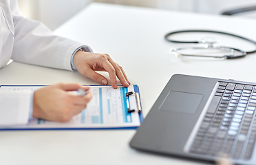 Image showing doctor with laptop and medical report at hospital