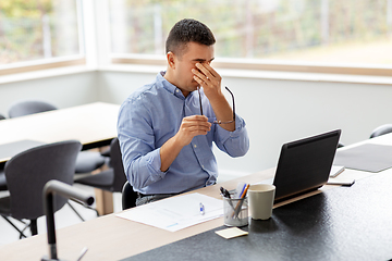 Image showing tired man with laptop working at home office