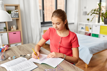 Image showing student girl with ruler drawing line in notebook