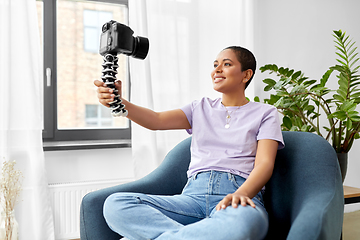 Image showing female blogger with camera video blogging at home