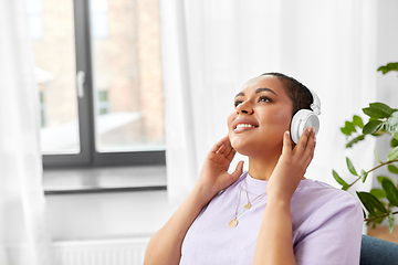 Image showing woman in headphones listening to music at home