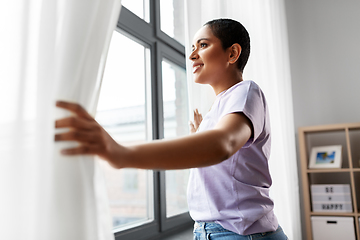 Image showing happy african american woman looking out of window