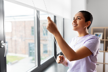 Image showing woman opening window roller blinds