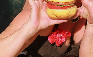 Image showing Female eating a hamburger.