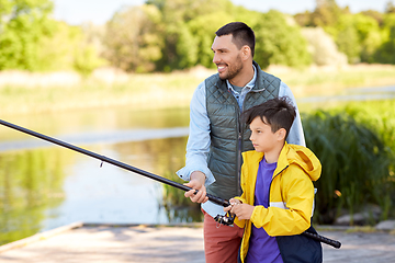 Image showing happy smiling father and son fishing on river