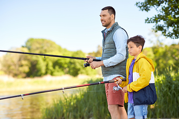 Image showing happy smiling father and son fishing on river