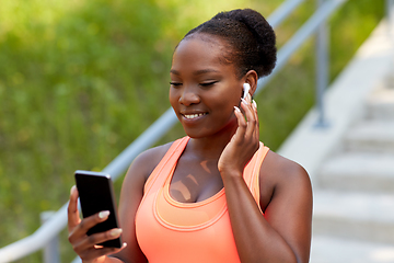 Image showing african american woman with earphones and phone