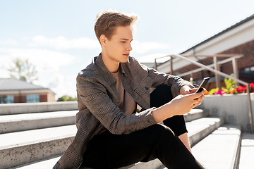 Image showing teenage boy using smartphone in city