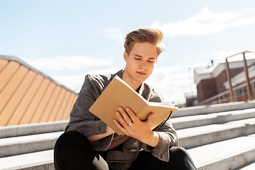 Image showing young man with notebook or sketchbook in city