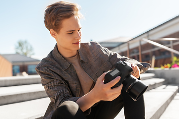 Image showing young man with camera photographing in city