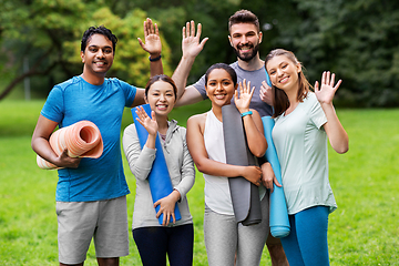 Image showing group of happy people with yoga mats at park