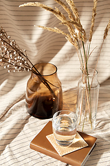 Image showing glass of water, decorative dried flowers in vases