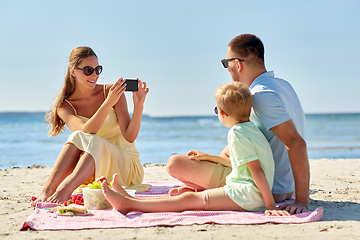 Image showing family with smartphone photographing on beach