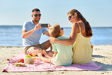 Image showing family with smartphone photographing on beach