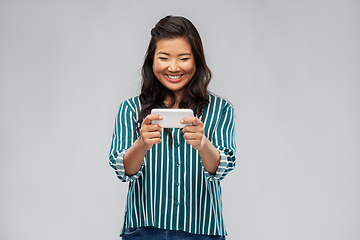 Image showing happy asian woman using smartphone