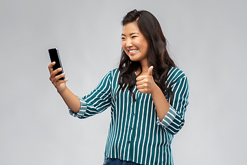 Image showing asian woman with smartphone showing thumbs up
