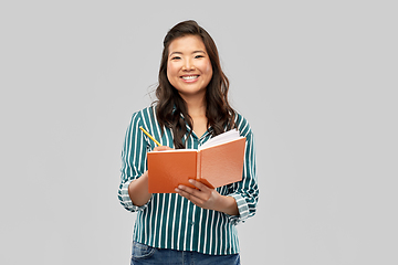 Image showing happy asian student woman with diary and pencil