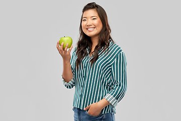 Image showing happy smiling asian woman holding green apple