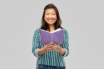 Image showing happy asian woman reading book