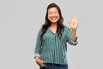 Image showing happy asian woman in glasses waving hand