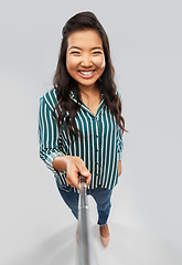 Image showing happy asian woman taking picture with selfie stick