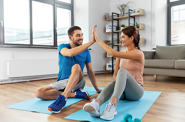 Image showing couple doing sports and making high five at home